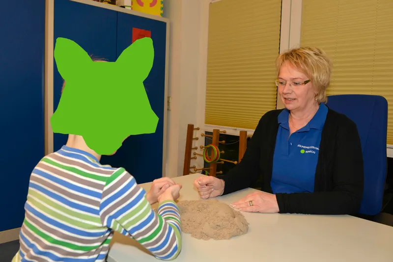 Ergotherapie mit einem Kind am Therapiesand