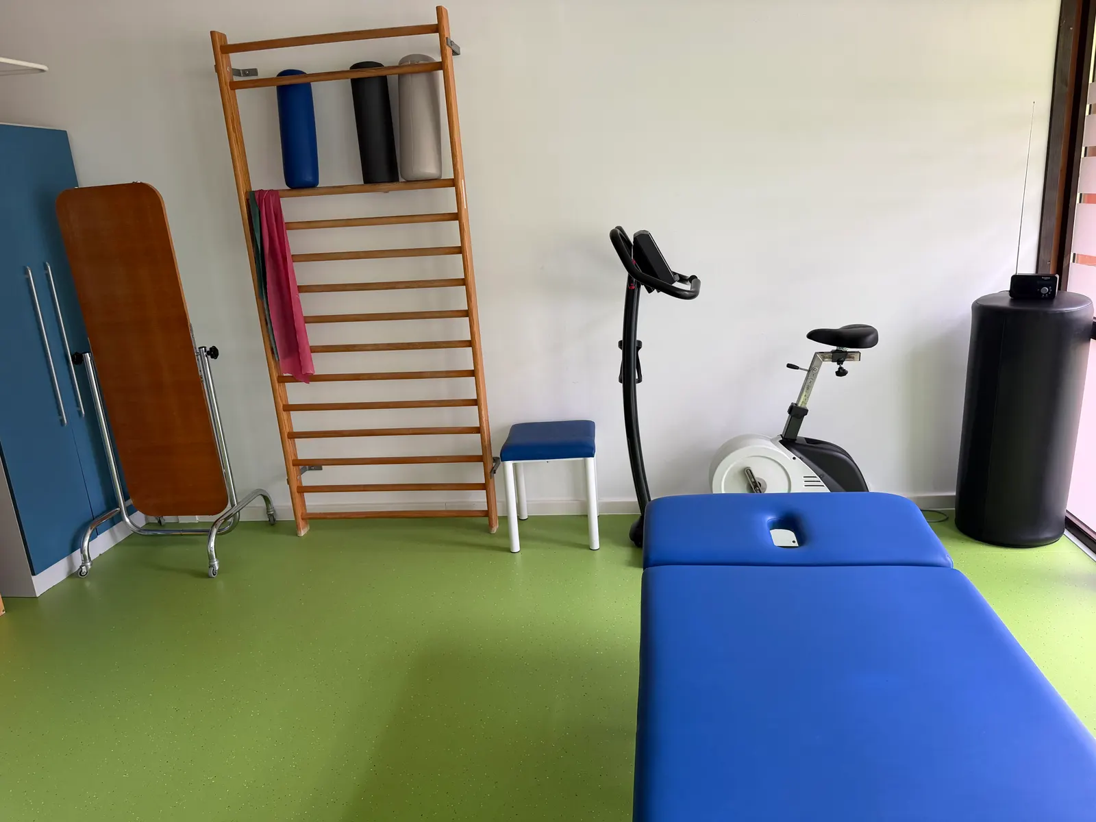 Neurologischer Therapieraum mit Sprossenwand, Ergometer und Behandlungsliege